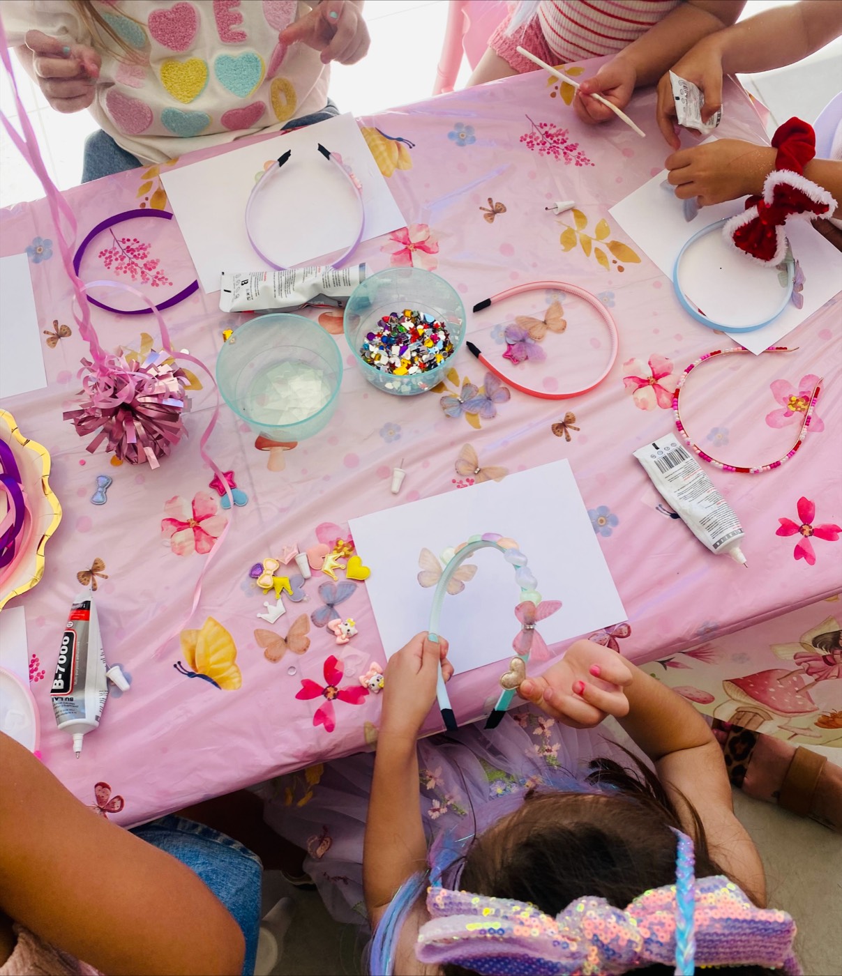Craft table covered in headbands, gems and butterflies