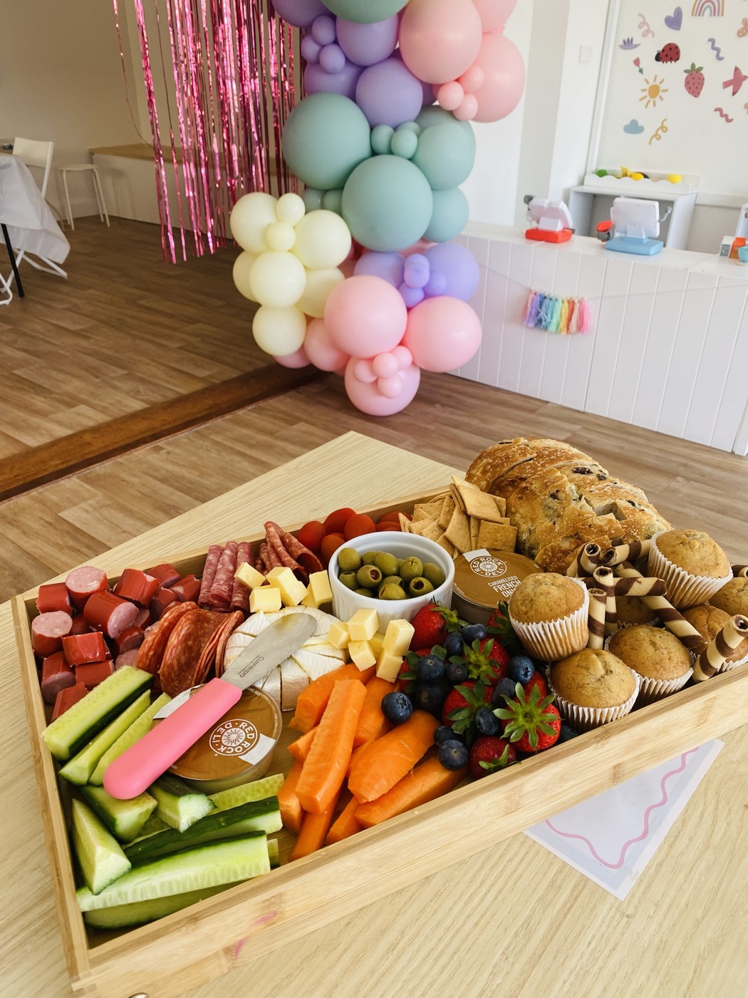 Fresh grazing platter and balloon garland at a party