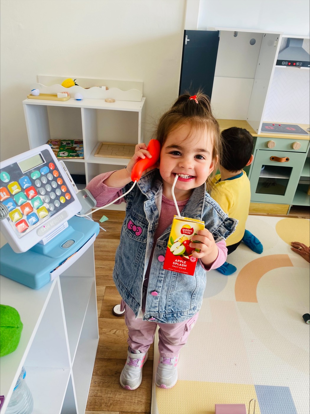 Toddler playing shops in the play kitchen